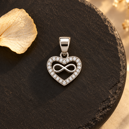 Silver heart-shaped pendant on a matte black slate plate with light reflections.