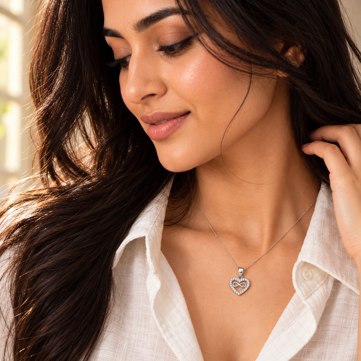 Close-up of Noya wearing the silver infinity heart pendant on a delicate chain.