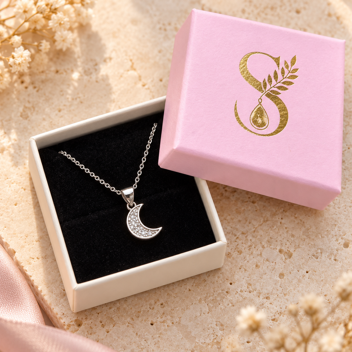 Silver moon pendant displayed in a pink Silvanya jewellery box with black velvet.