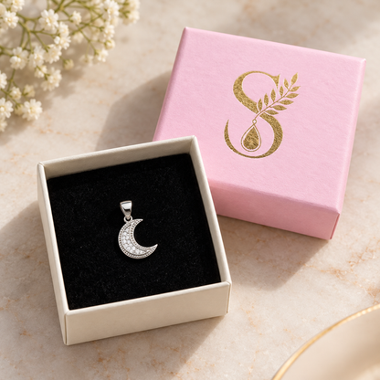 Silver crescent pendant presented inside an open Silvanya gift box on black velvet.