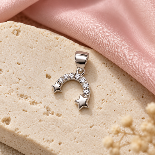Silver star pendant lying elegantly on a matte ivory slab with blush pink silk.