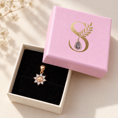 Rose gold sun pendant displayed inside an open pale pink Silvanya jewellery gift box.