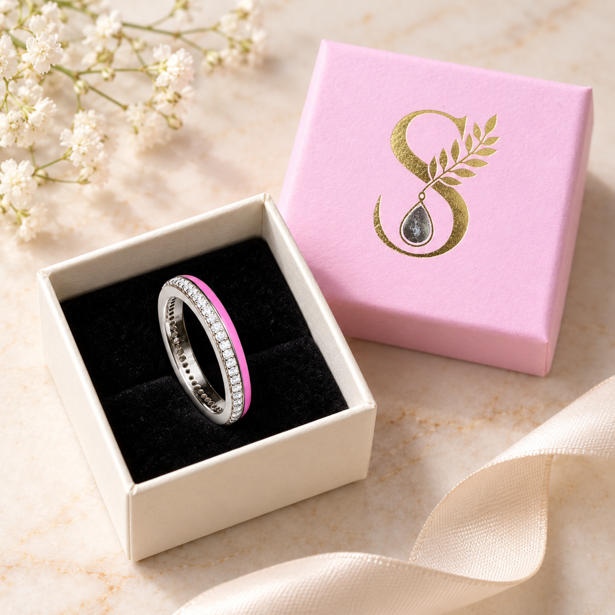 Silver ring presented inside a pale pink Silvanya jewelry box with black velvet lining.