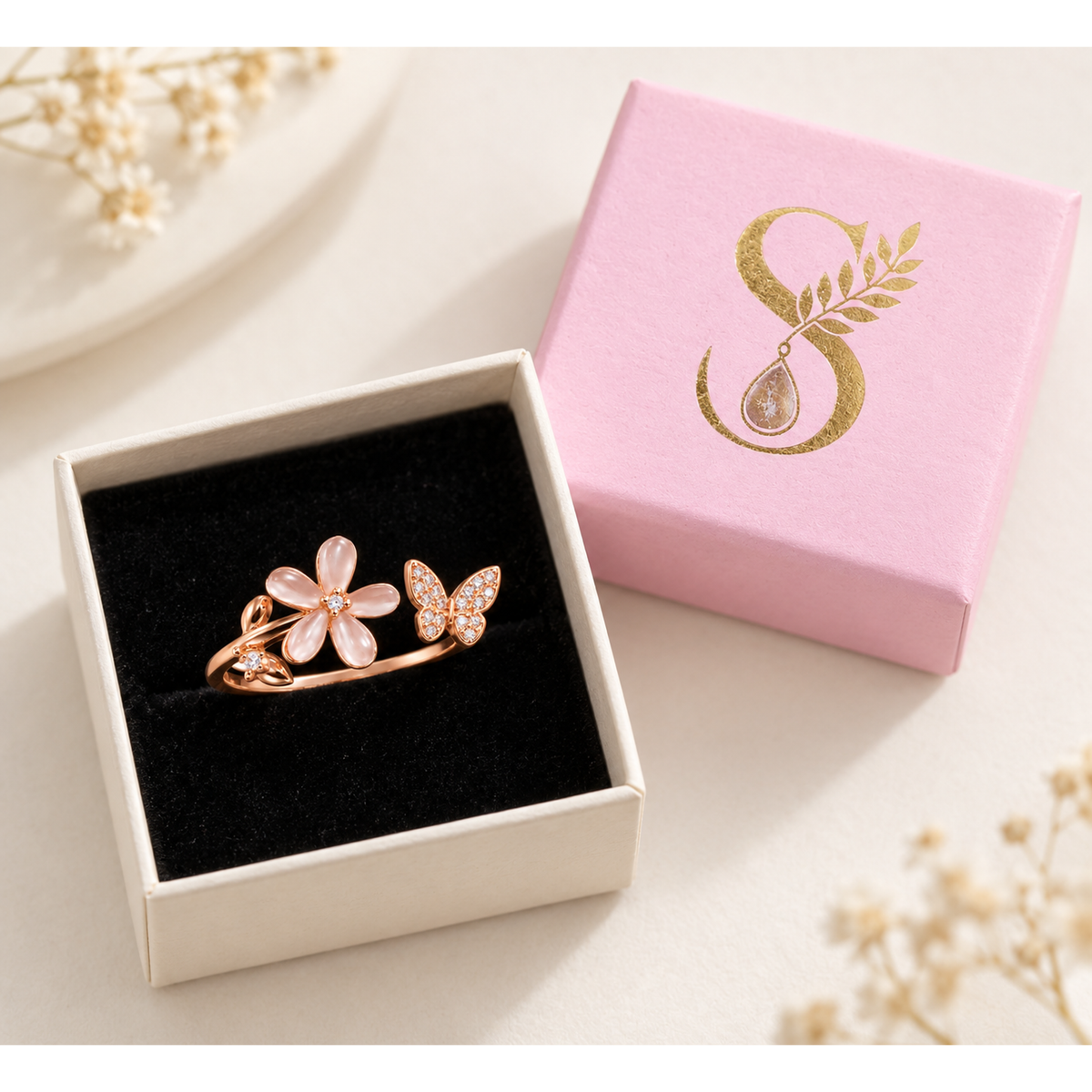 Rose gold silver bypass ring inside Silvanya pale pink box with black velvet cushion.