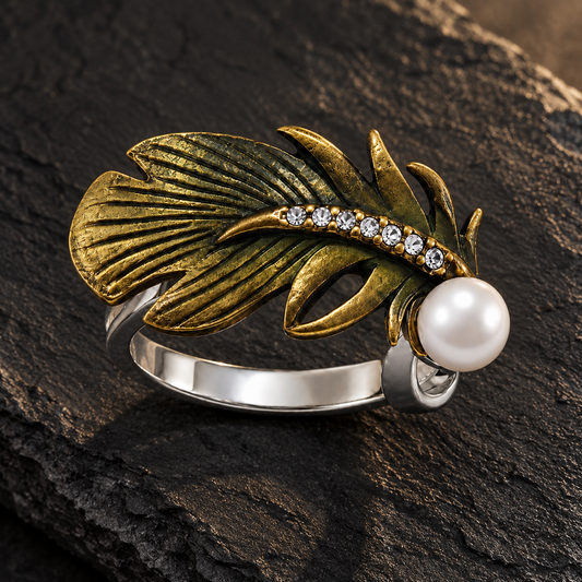 Oxidised feather pearl silver ring resting on a matte black slate tile.