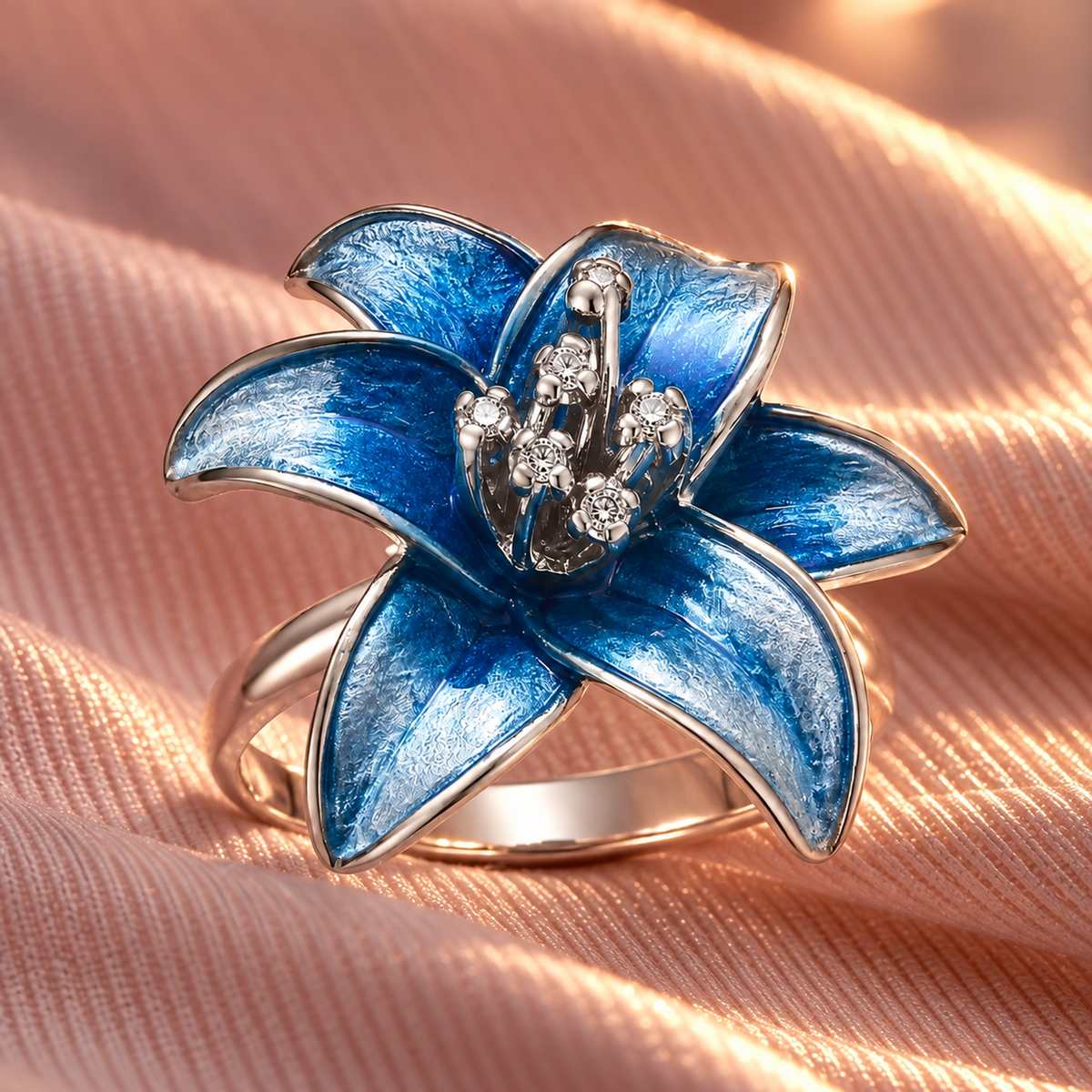 Blue enamelled silver ring placed gracefully on pale pink silk fabric.