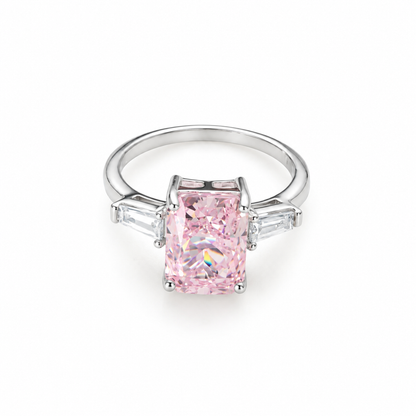 A sterling silver ring with a radiant-cut pink stone and clear side baguettes on a pure white background.