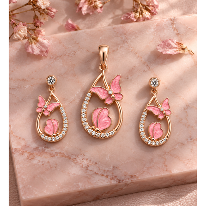 Rose gold butterfly jewellery set resting on a blush pink marble surface with dried petals.