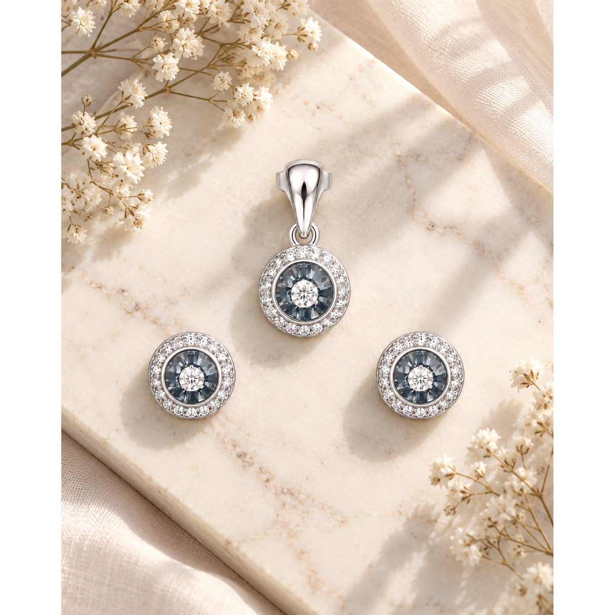 Jewellery set placed on white marble next to small white flowers.
