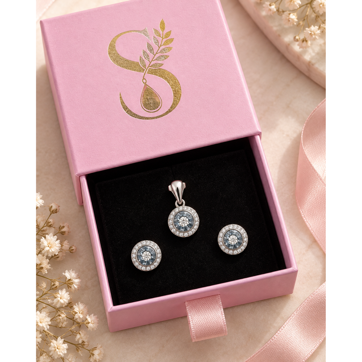 Jewellery set laid inside a pink velvet-lined gift box.