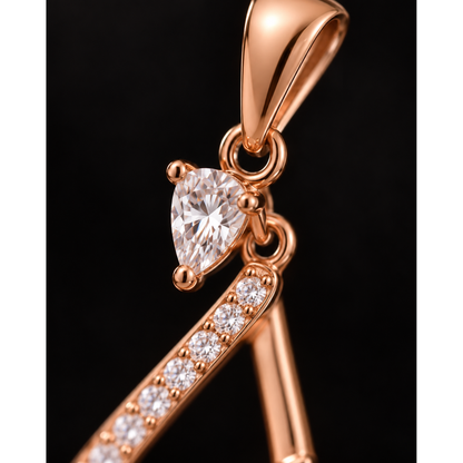Extreme close-up of the pendant's top solitaire stone and the stone-set curve below.