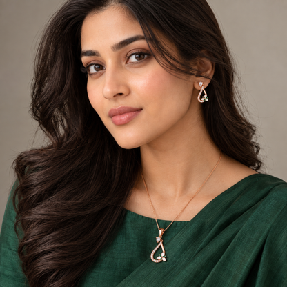 Woman in a green blouse looking at the camera, wearing the drop pendant and earrings.