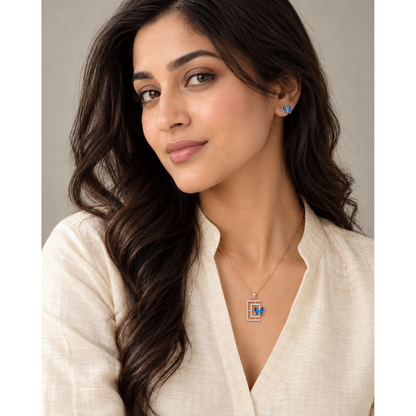 Woman in ivory kurta looking at camera, wearing the butterfly pendant and studs.